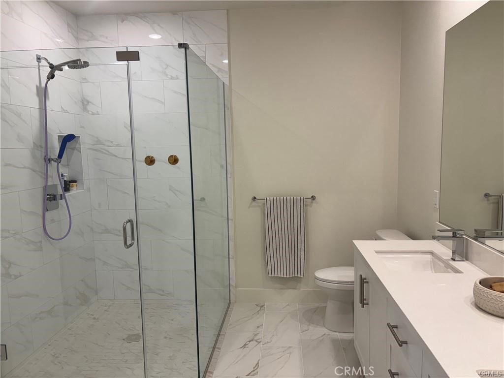 16175 Dawn Way, Unit 108 Tustin, CA 92782 - Photo 7 of 12 a bathroom with a granite countertop sink a toilet and shower