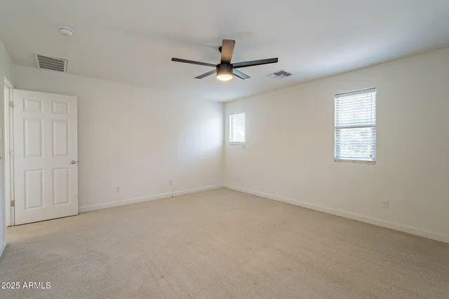 an empty room with a window and a fan