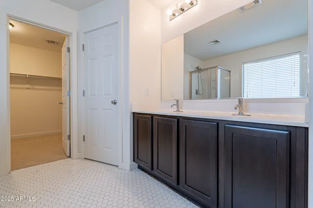 a bathroom with a double vanity sink and mirror