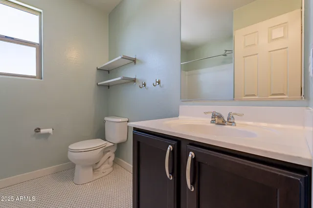 a bathroom with a granite countertop sink a toilet and a mirror