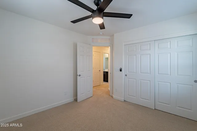 an empty room with a ceiling fan and a window
