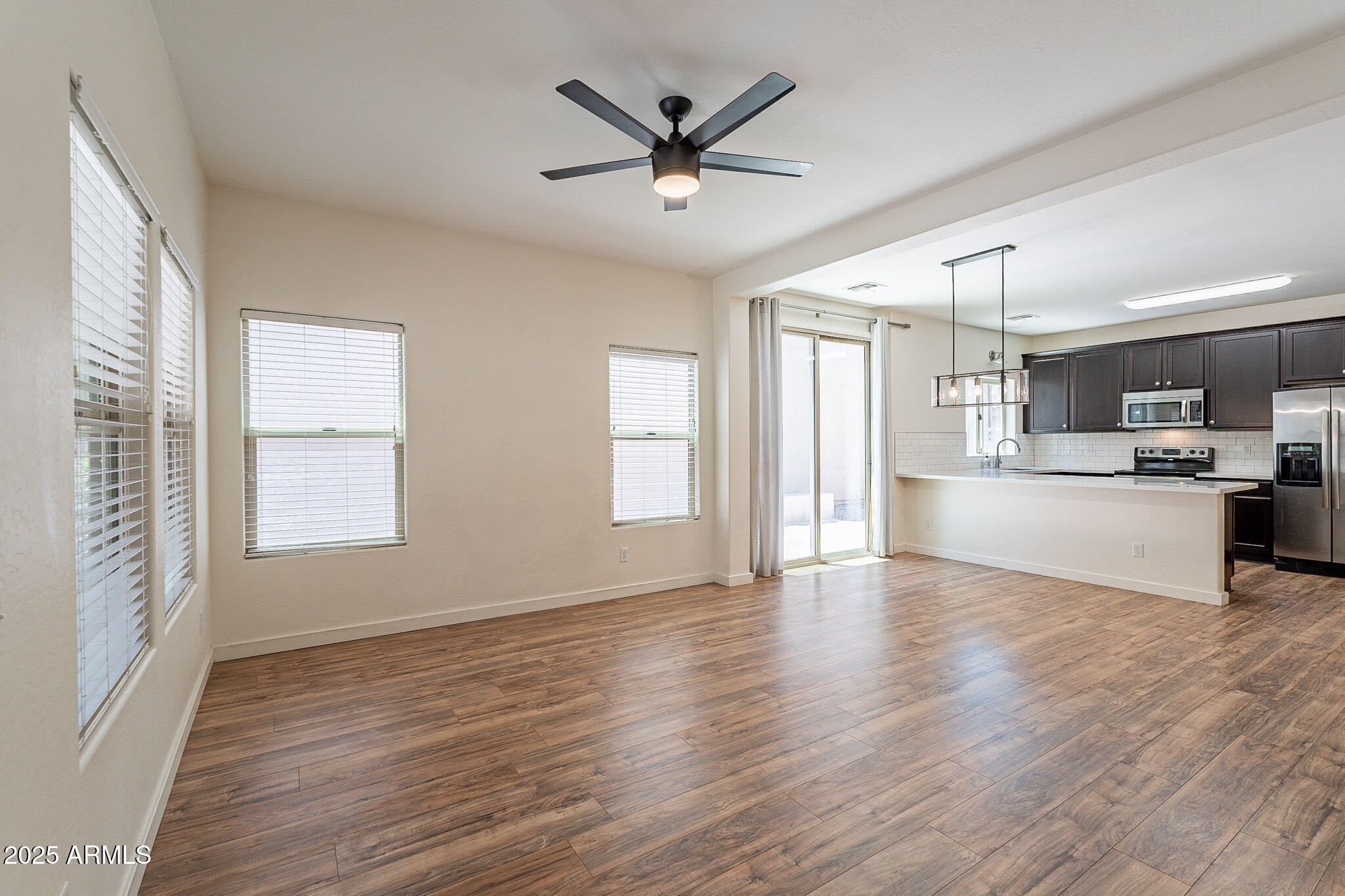 1061 South Hawk Lane Gilbert, AZ 85296 - Photo 4 of 23 a view of an empty room with window and wooden floor
