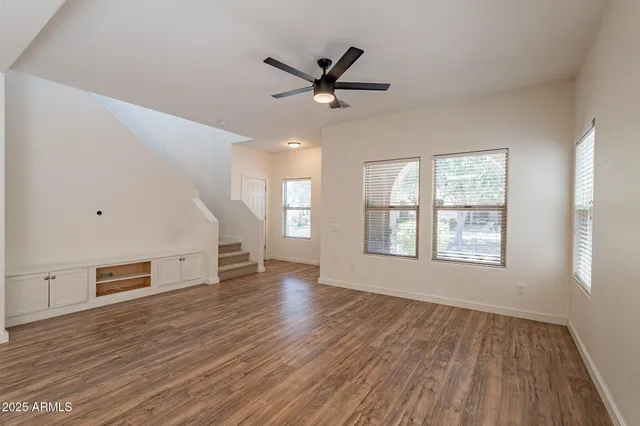 a view of an empty room with a window and wooden floor
