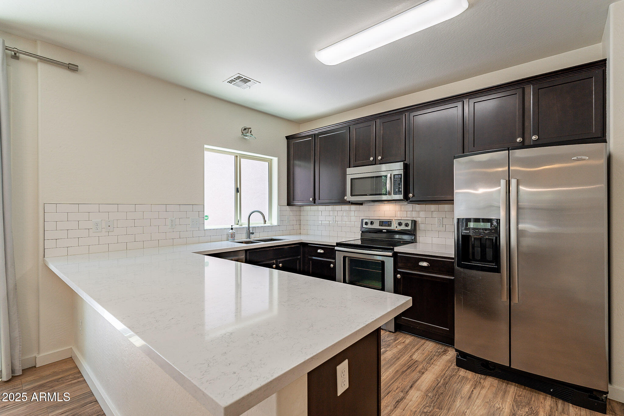 1061 South Hawk Lane Gilbert, AZ 85296 - Photo 7 of 23 a kitchen with stainless steel appliances granite countertop a sink stove microwave and refrigerator