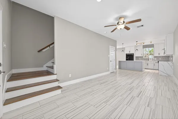 a view of a livingroom with wooden floor and staircase