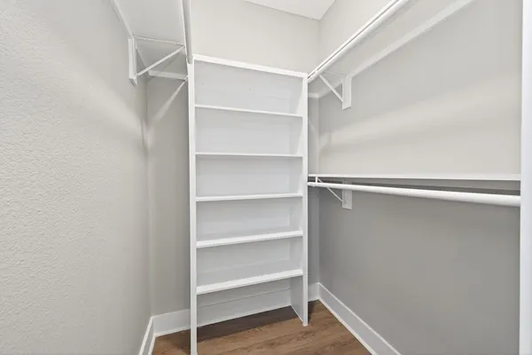 a view of walk in closet with empty racks