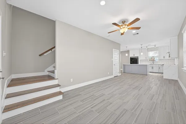a view of a kitchen with wooden floor and a ceiling fan