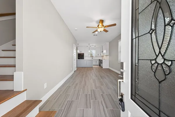 a view of a room with wooden floor and ceiling fan