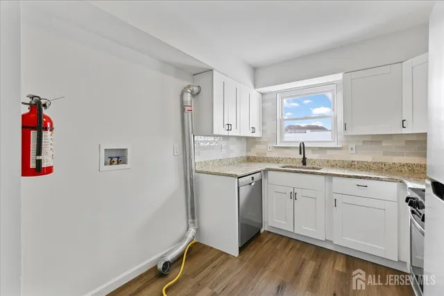 a kitchen with a sink cabinets and wooden floor