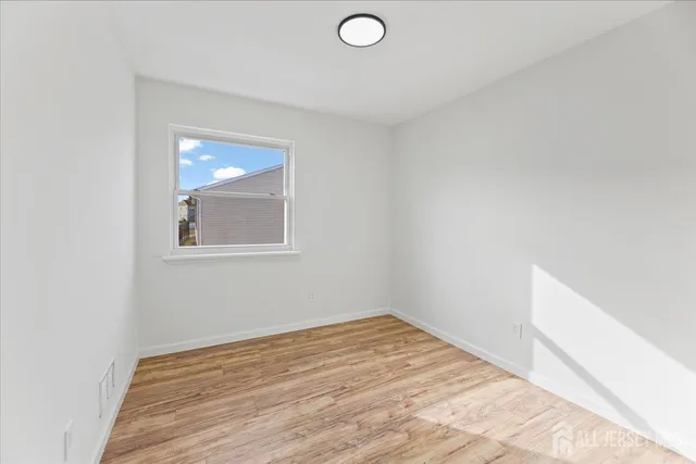 a view of a room with wooden floor and white walls