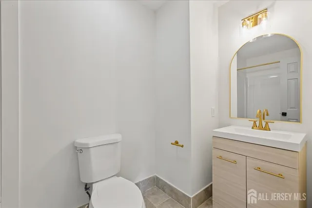 a bathroom with a toilet sink vanity and mirror