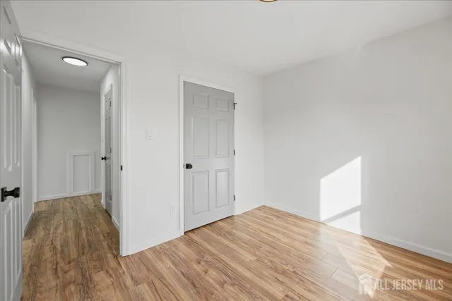 a view of a room with wooden floor and a bathroom