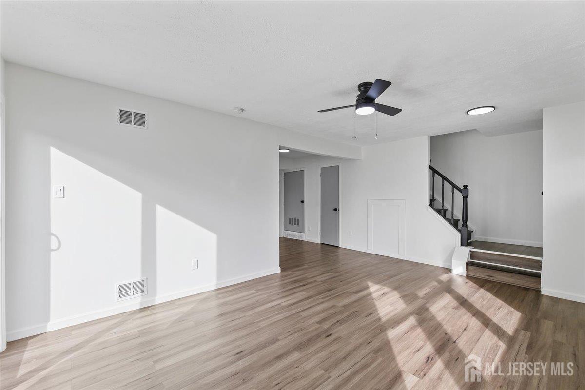 13 Lamont Court Sicklerville, NJ 08081 - Photo 6 of 25 a view of an empty room with wooden floor and a ceiling fan