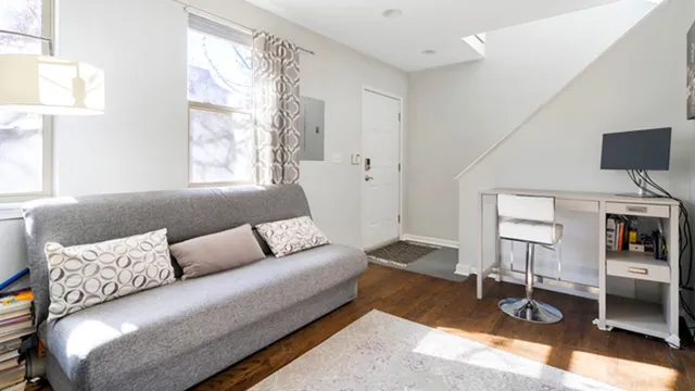 a living room with furniture a flat screen tv and a window
