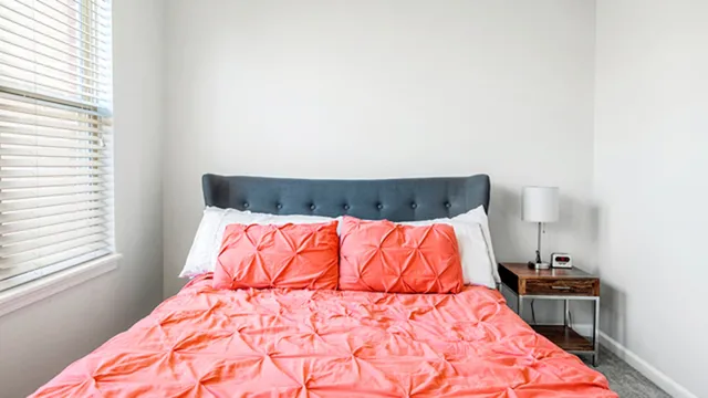 a bed sitting in a bedroom next to a window