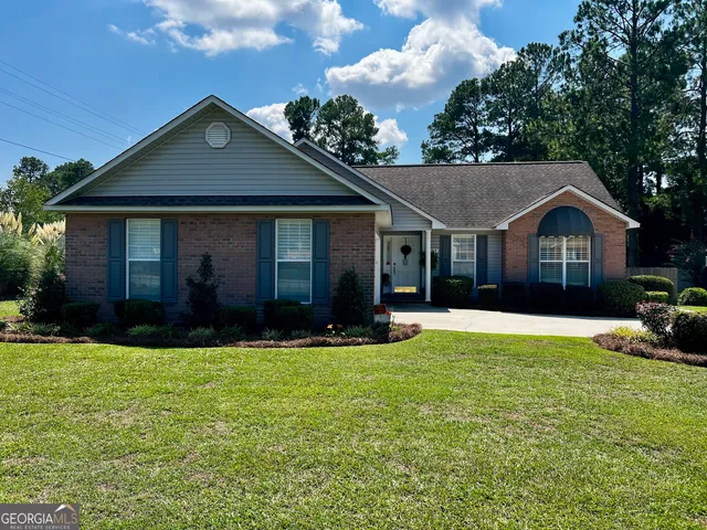 a front view of a house with yard and green space