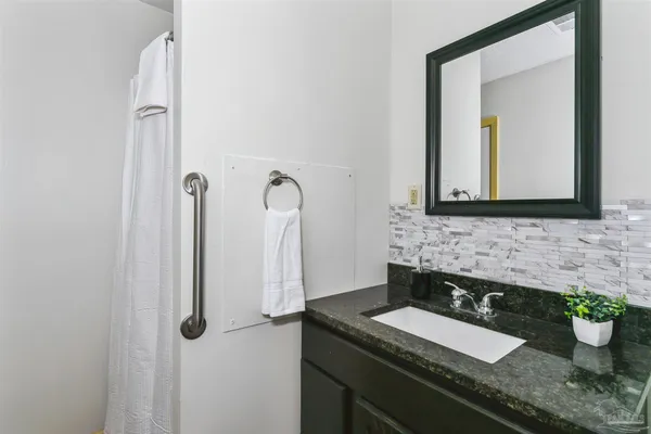 a bathroom with a granite countertop sink and a mirror