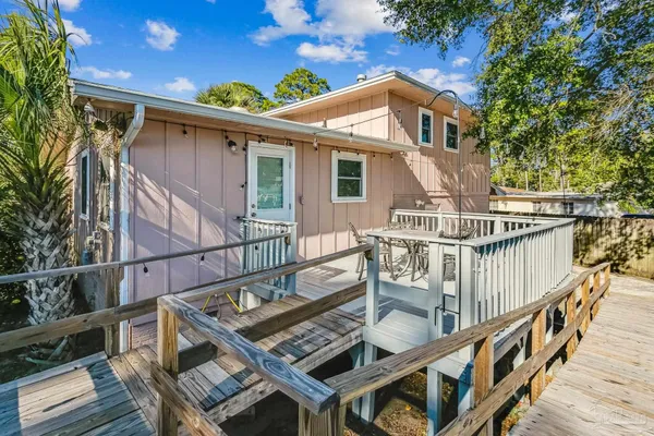 a view of a house with wooden deck front of house
