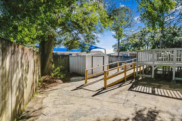 a view of a deck with a floor to ceiling window and wooden fence