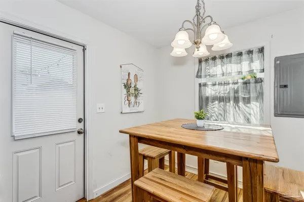 a view of a dining room with furniture a chandelier and wooden floor