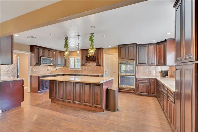 a kitchen with stainless steel appliances granite countertop a sink and cabinets