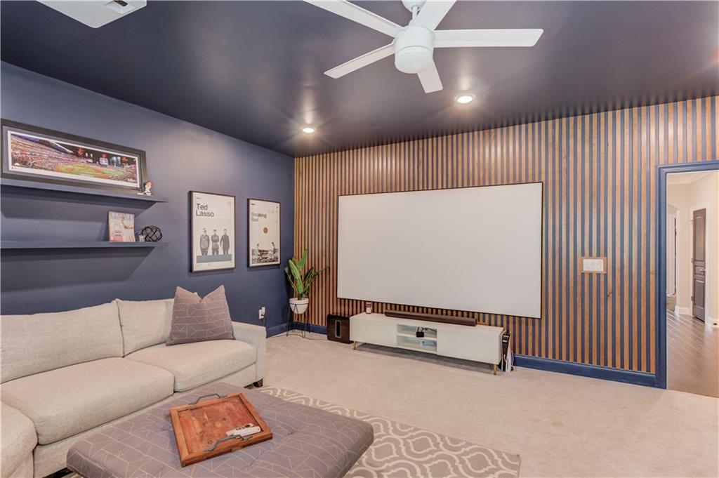 542 Flyingbolt Run Canton, GA 30115 - Photo 31 of 55 a living room with furniture a projector and a flat screen tv