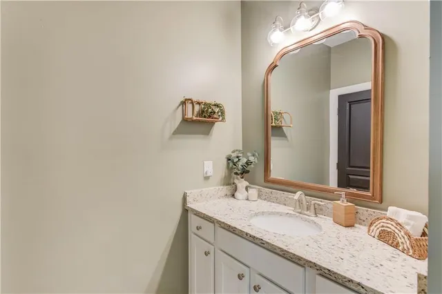 a bathroom with a granite countertop double vanity sink and a mirror
