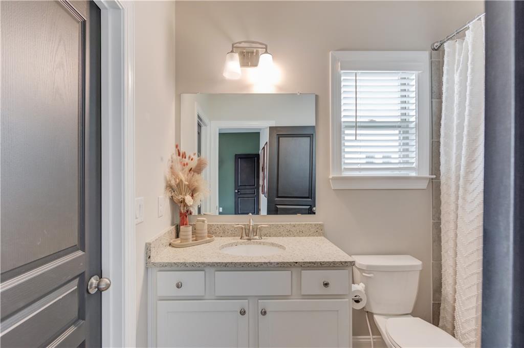542 Flyingbolt Run Canton, GA 30115 - Photo 40 of 55 a bathroom with a granite countertop sink a toilet and a mirror