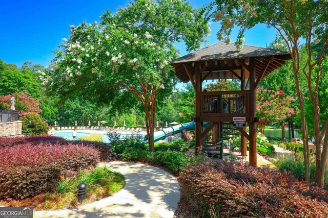 a view of a swimming pool with a lawn chairs under an umbrella