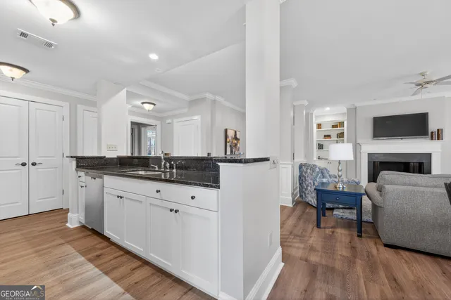 a large living room with stainless steel appliances granite countertop couches a fireplace and a flat screen tv