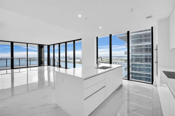 a view of a white room with a white bed