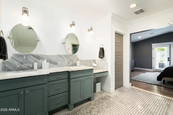 a en suite bathroom with a double vanity sink and a mirror