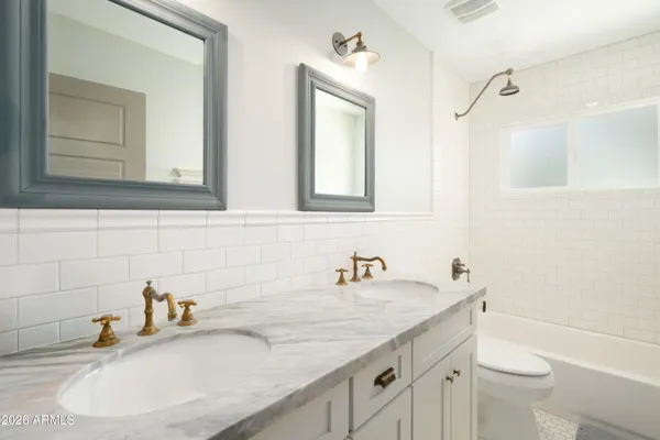 a bathroom with a granite countertop sink a toilet and a mirror