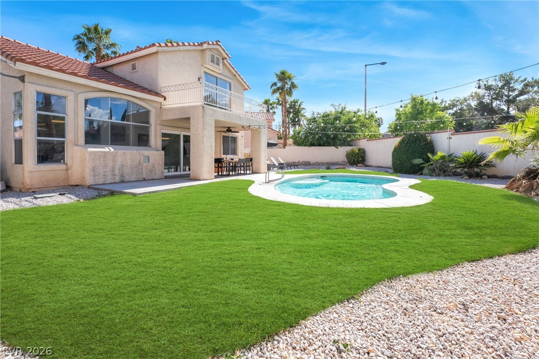 1941 Ivy Point Lane Las Vegas, NV 89134 - Photo 20 of 21 This residence features a lush backyard with a freeform pool, paved patio, and upper-level balcony for elevated outdoor living.