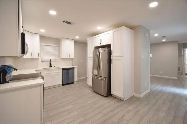 a kitchen with a refrigerator sink and cabinets