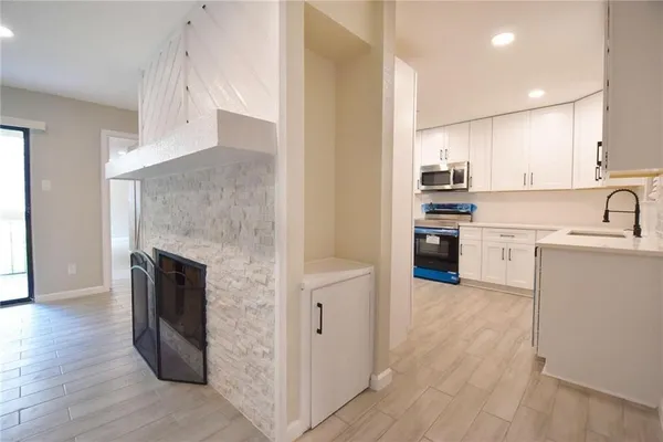 a kitchen with stainless steel appliances granite countertop a refrigerator a stove and a sink