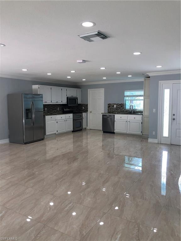 a large kitchen with stainless steel appliances a large counter top and oven