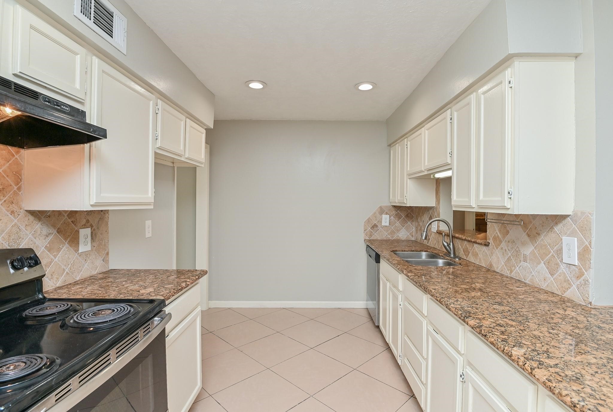 10019 Overview Drive Sugar Land, TX 77498 - Photo 13 of 30 a kitchen with granite countertop a sink stove and cabinets