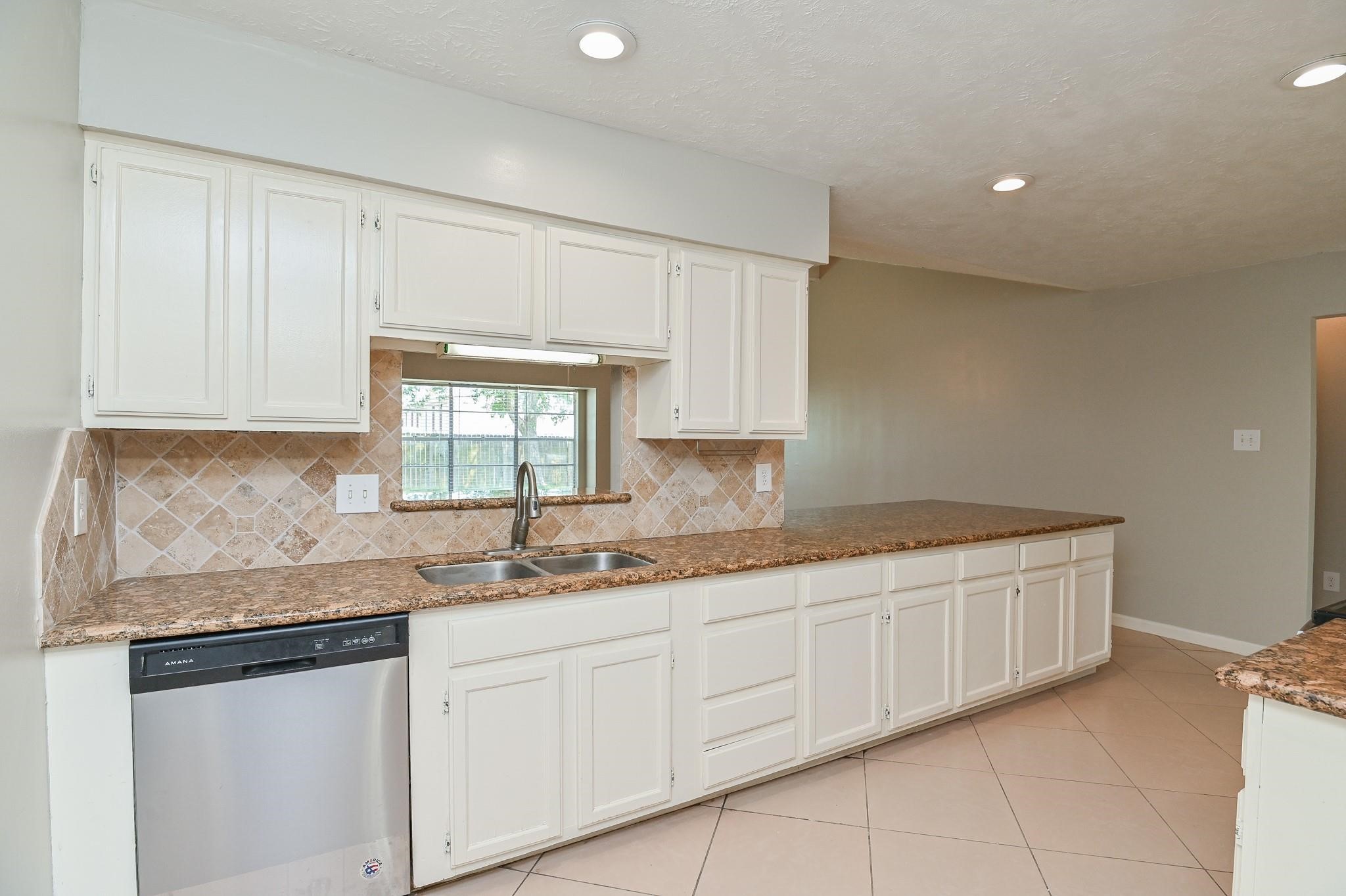 10019 Overview Drive Sugar Land, TX 77498 - Photo 14 of 30 a kitchen with granite countertop white cabinets and white stainless steel appliances