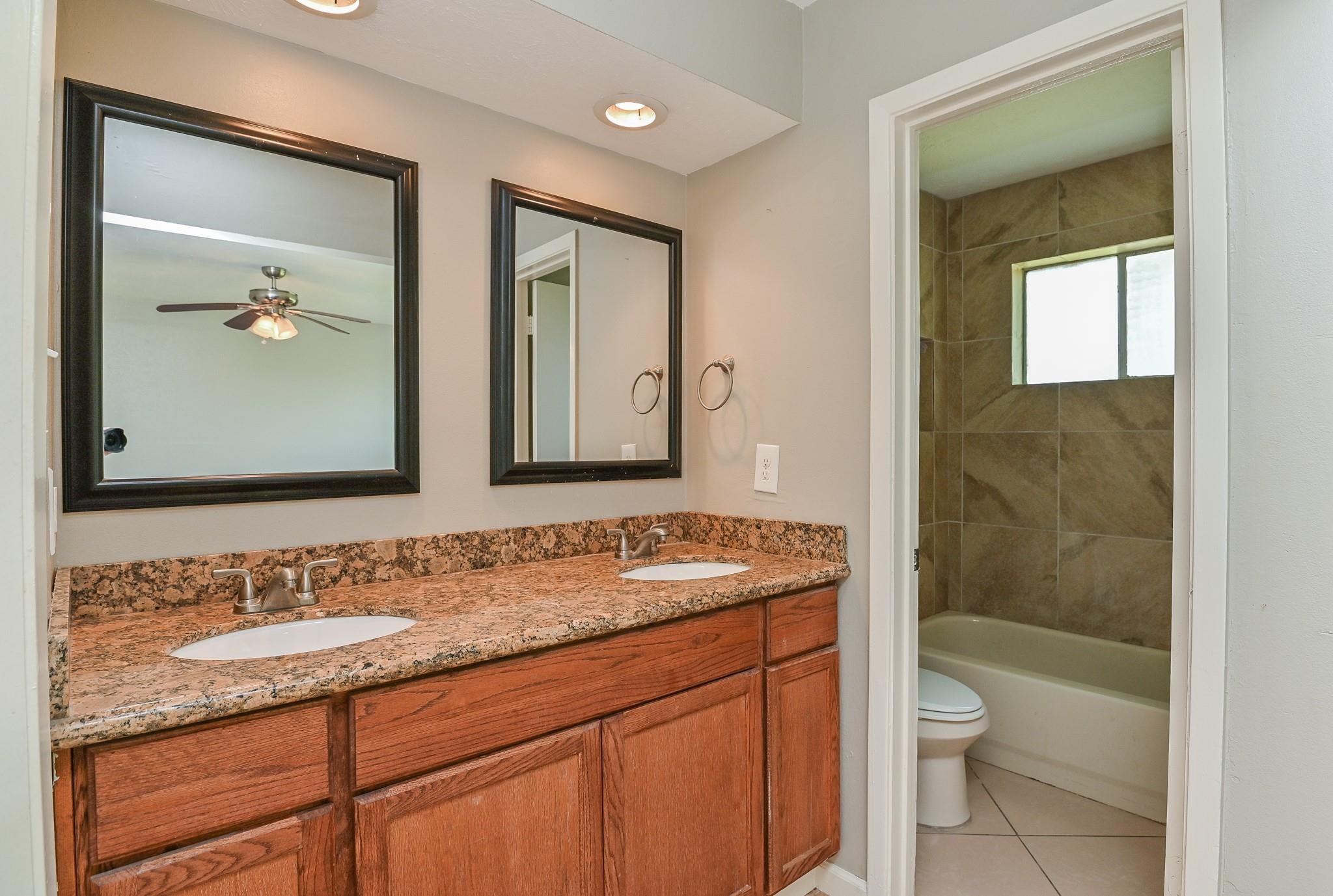 10019 Overview Drive Sugar Land, TX 77498 - Photo 20 of 30 a bathroom with a granite countertop sink toilet and shower