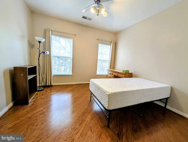 a bedroom with a bed and wooden floor