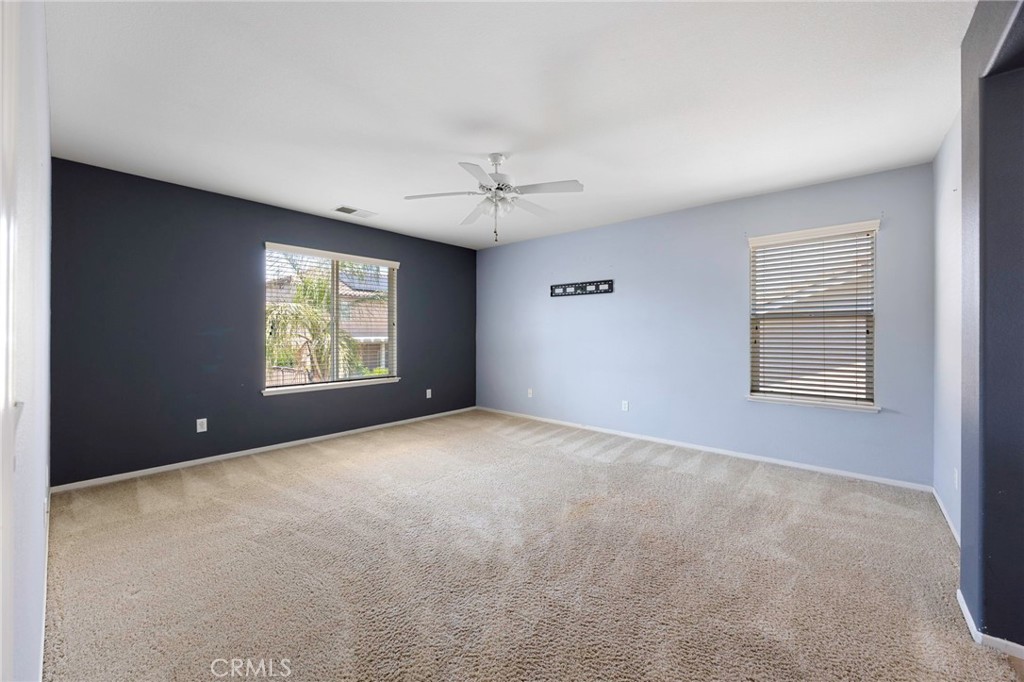 151 Ropango Way Hemet, CA 92545 - Photo 17 of 28 an empty room with windows and ceiling fan