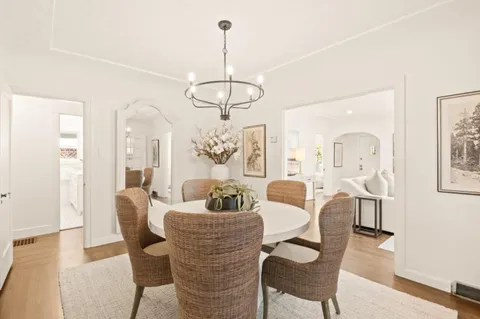a dining room with furniture a chandelier and wooden floor