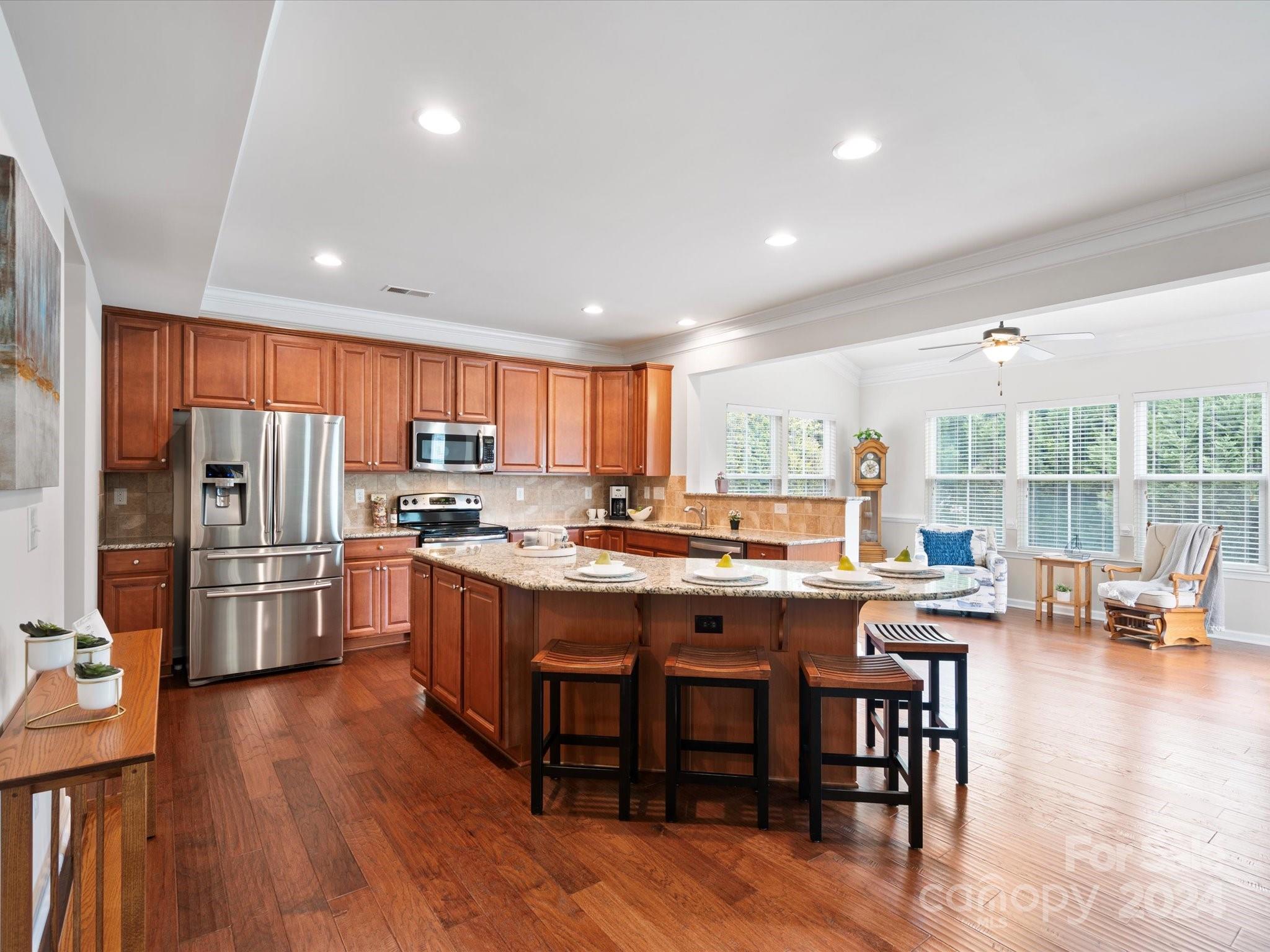 1617 Ridgehaven Road Waxhaw, NC 28173 - Photo 11 of 47 a kitchen with stainless steel appliances granite countertop a table chairs refrigerator and a sink