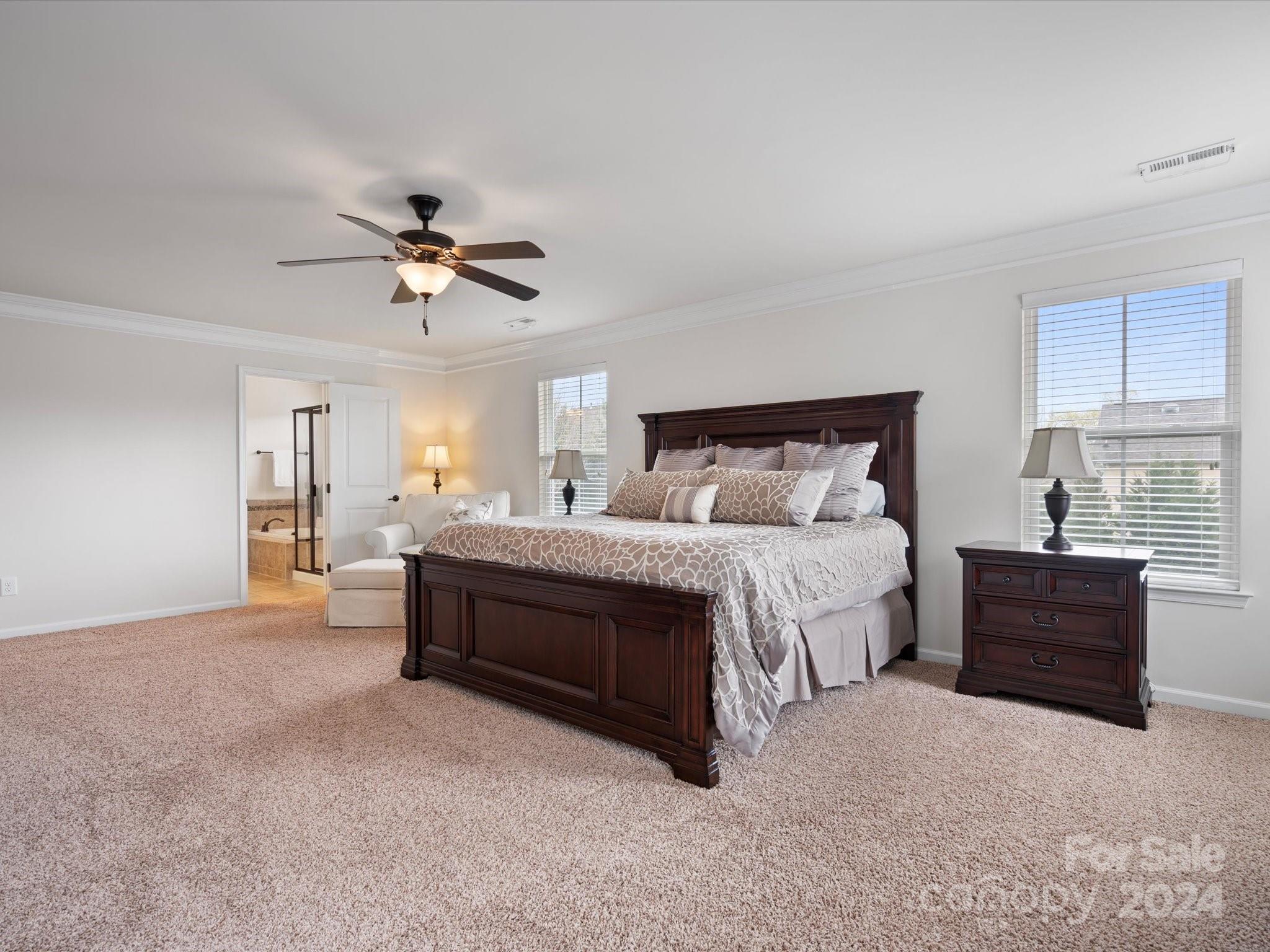 1617 Ridgehaven Road Waxhaw, NC 28173 - Photo 24 of 47 a spacious bedroom with a bed and a chandelier