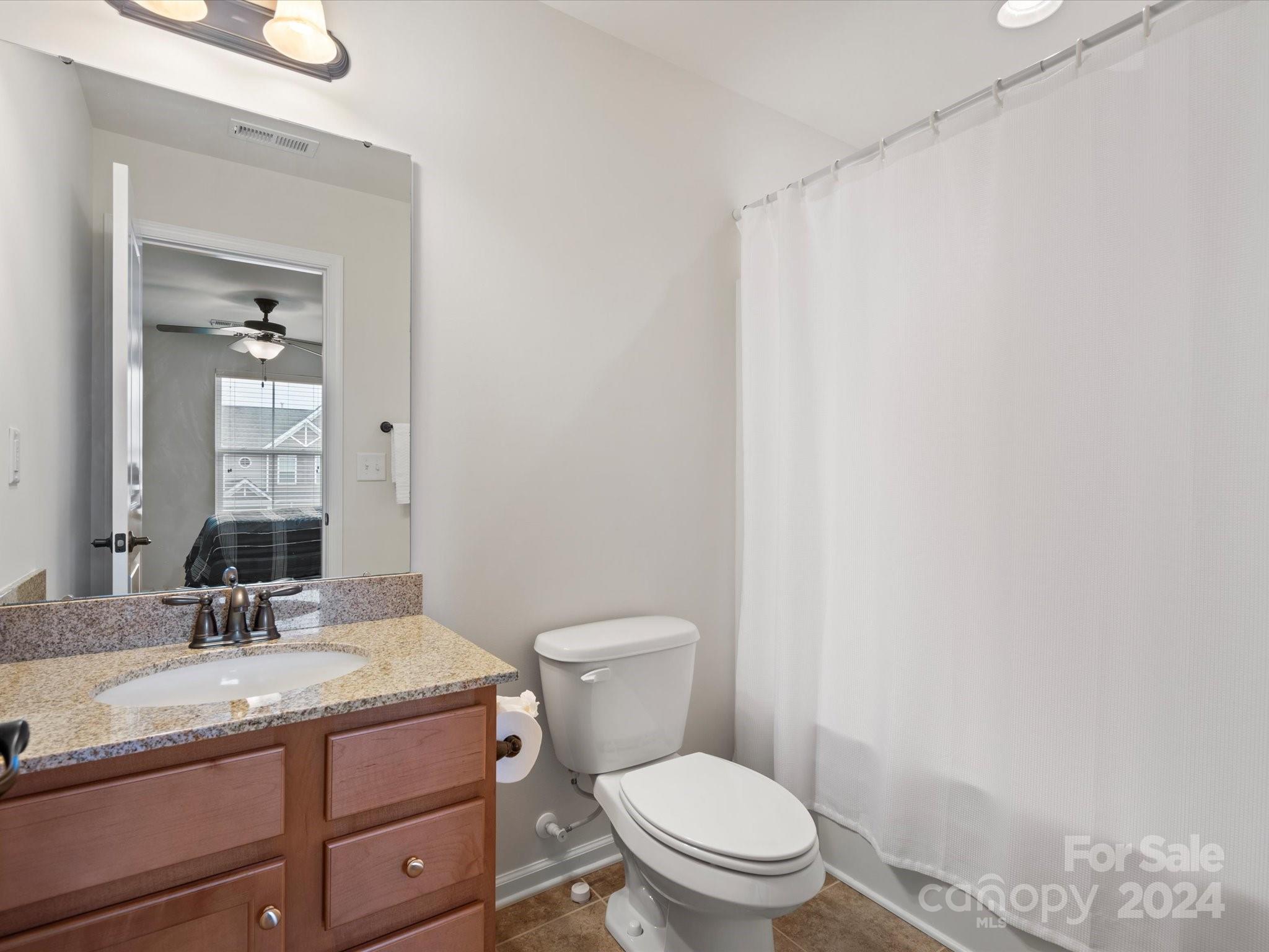 1617 Ridgehaven Road Waxhaw, NC 28173 - Photo 36 of 47 a bathroom with a granite countertop sink a toilet and a mirror