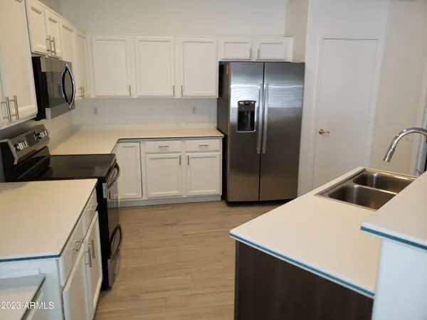 a kitchen with a sink a refrigerator and a stove top oven