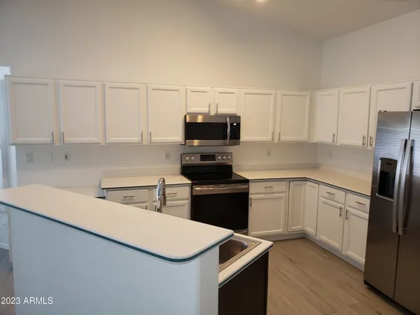 a kitchen with white cabinets and stainless steel appliances