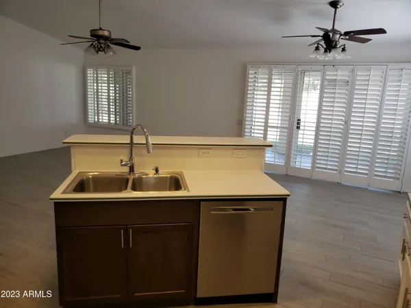 a kitchen with a sink a window and wooden floor