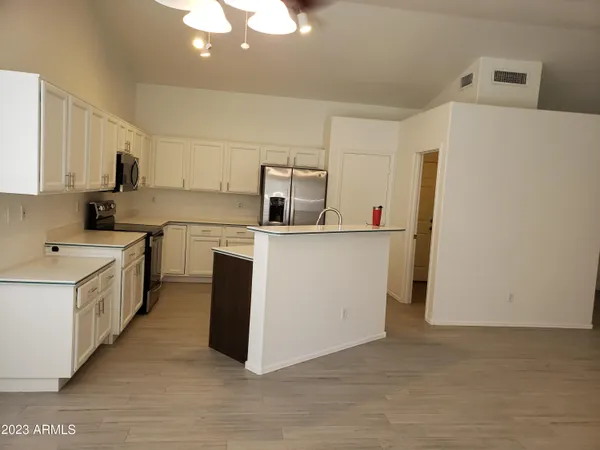 a kitchen with a sink a stove a refrigerator and white cabinets